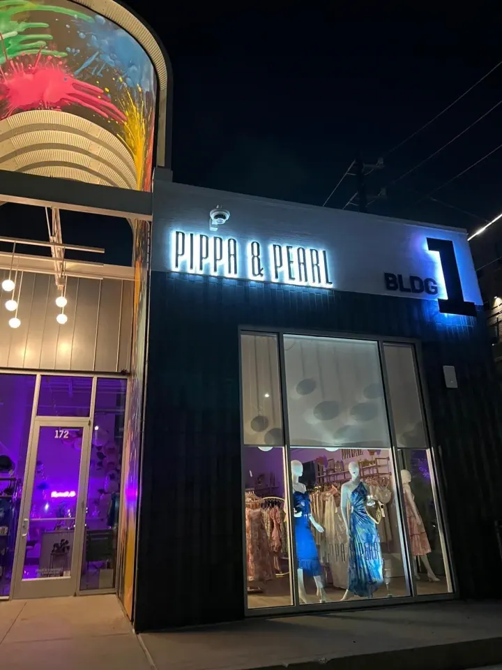 OPERA GALLERY storefront signs illuminated at night