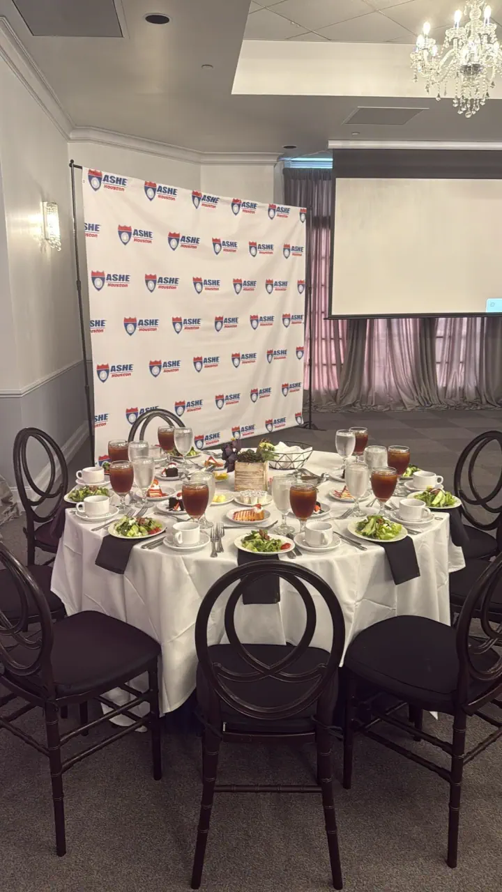 Branded event photo backdrop behind a display table