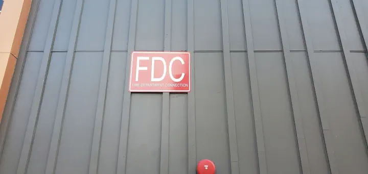 Red FDC sign mounted on a metal-clad exterior wall