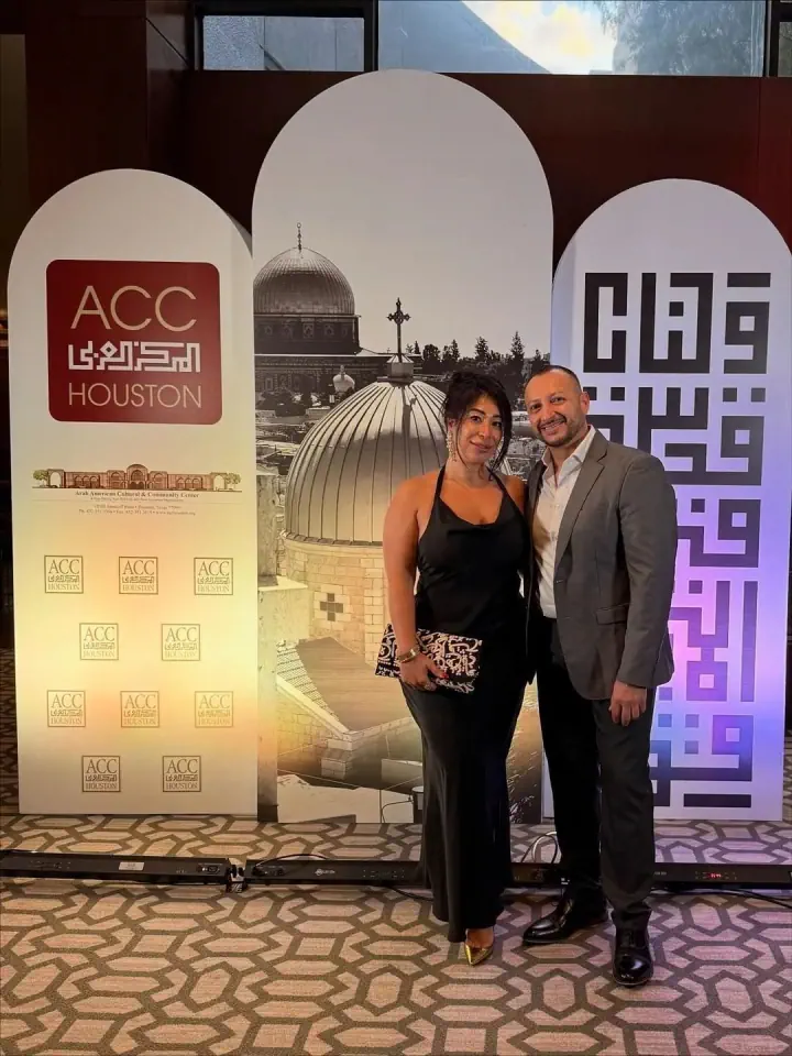 Two people standing before printed event backdrop panels
