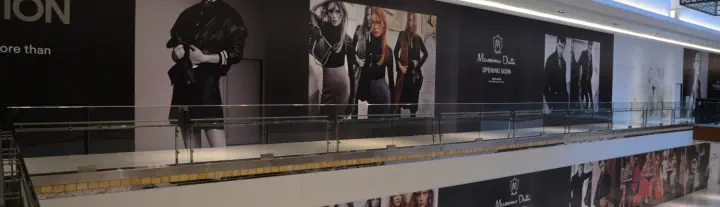 Fashion campaign graphics along a shopping mall corridor