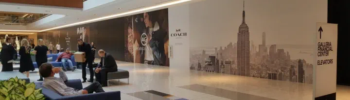 Printed cityscape wall graphics in a shopping mall corridor