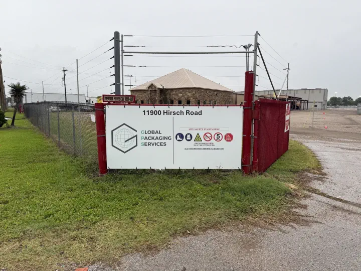 Global Packaging Services sign mounted on a security gate